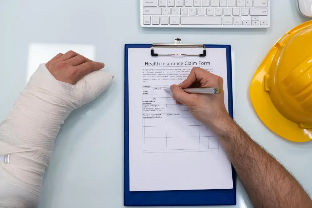 Injured worker filling health insurance claim form.